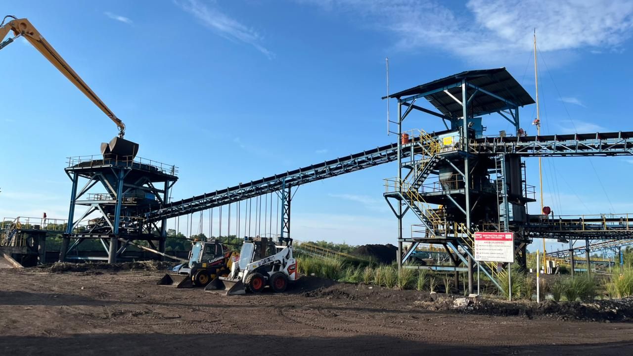 Hopper dan conveyor batubara dengan dua skid steer loader