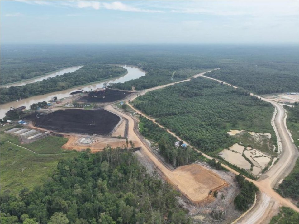 Foto udara stockpile batubara di tepi sungai